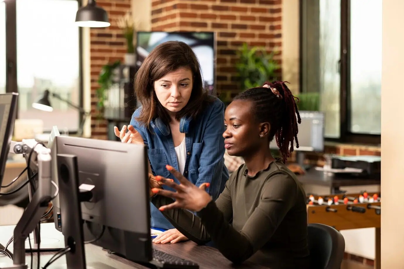 Коллеги проводят мозговой штурм у настольного компьютера.
